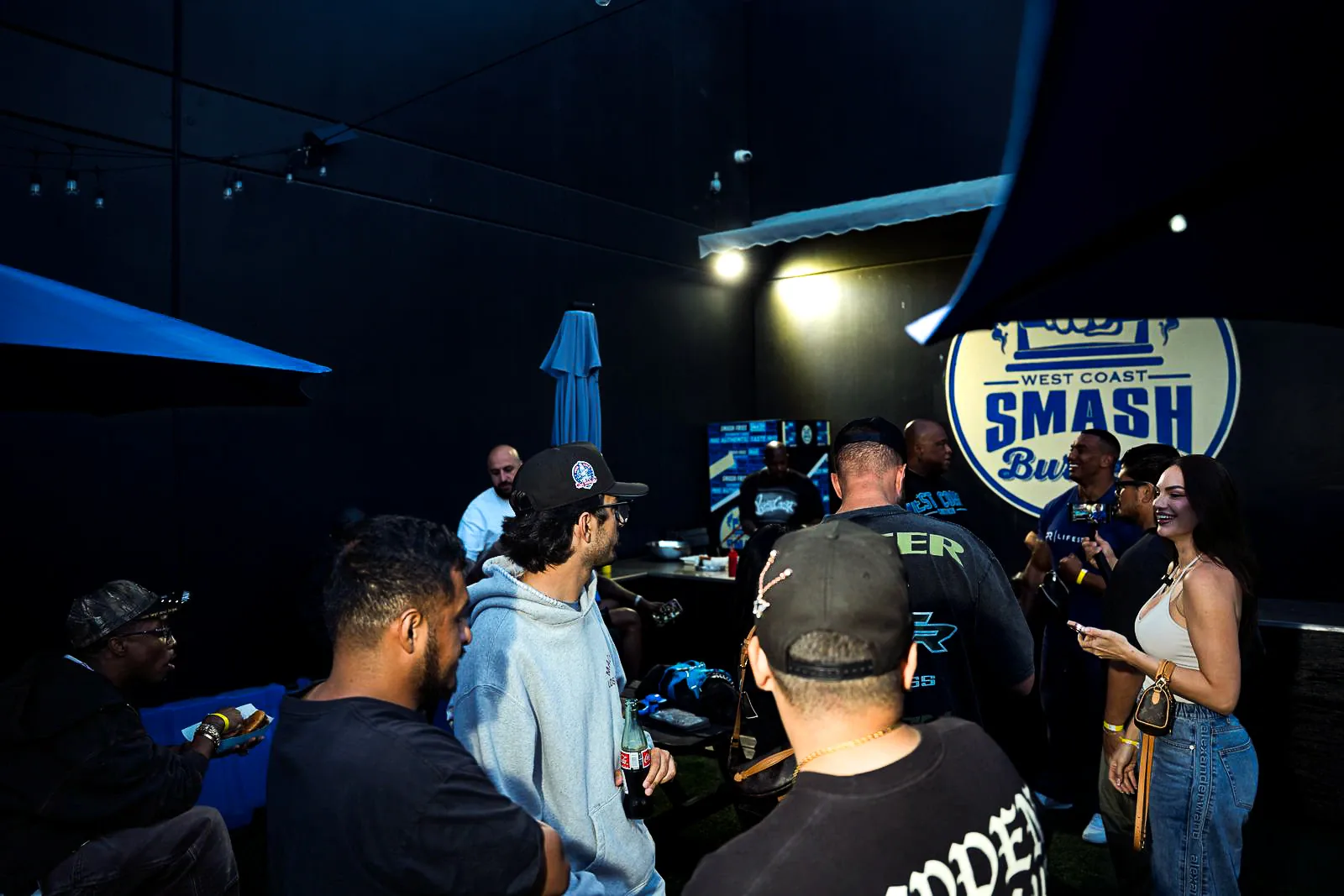 Guests gathering on the West Coast Customs outdoor patio during an evening event